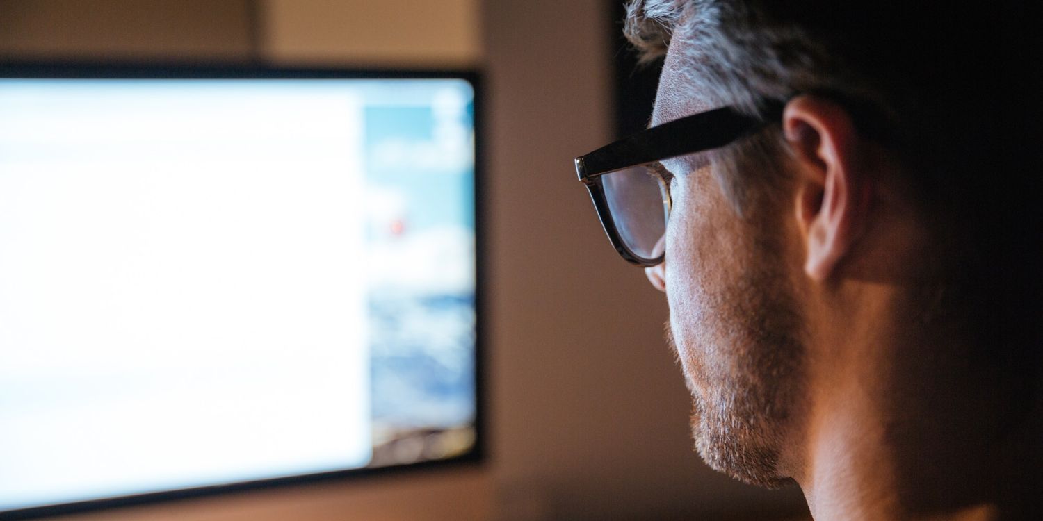 Concentrated man sitting and looking at screen of monitor