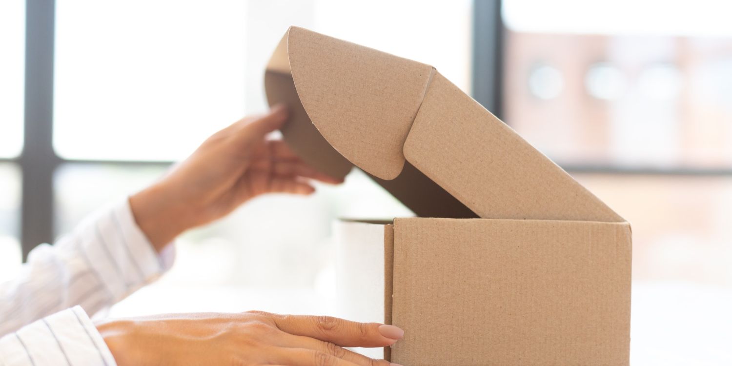 Lady opening box with new parcel, close-up